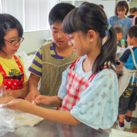 次は生地を折りたたんで 出張手打ちうどん作り体験 2018年5月27日 20180527-7.jpg – イリコスキー製麺所