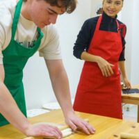 麺棒を使って生地を丁寧に伸ばしていく様子。 / Carefully flattening the dough using a rolling pin. 手打ちうどん作り体験教室 2026年1月 A6407930-1.jpg – イリコスキー製麺所