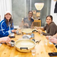 湯気の立つ大鍋を囲んで、打ちたてうどんを試食する時間。 / Tasting time around a steaming hot pot of freshly made udon. 手打ちうどん作り体験教室 2026年2月 iricosky-udon-tasting-steaming-hot-pot.jpg – イリコスキー製麺所