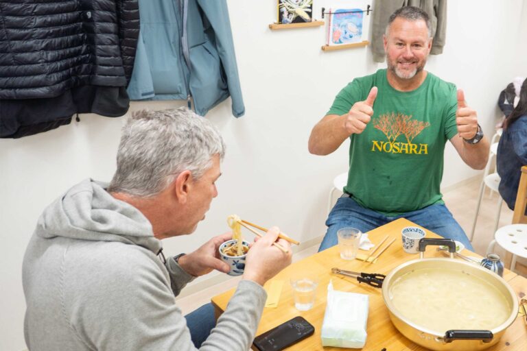 大阪のうどん体験教室でできたてのうどんを前に両手でサムズアップする男性 手打うどん作り体験教室 2026年1月 udon-class-thumbs-up.jpg – イリコスキー製麺所