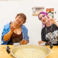 スイスからいらっしゃった女性2人が、できあがったうどんの大鍋の前でピースサインをして笑顔を見せている。 手打ちうどん作り体験教室 2026年5月 udon-class-peace-sign-finished-udon-pot.jpg – イリコスキー製麺所