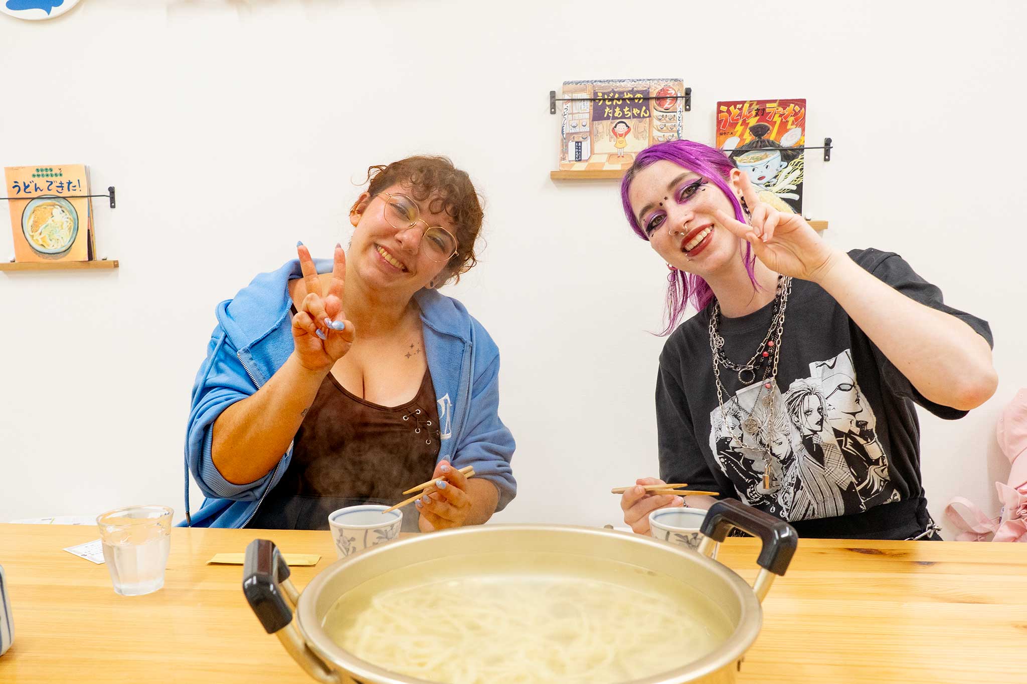 スイスからいらっしゃった女性2人が、できあがったうどんの大鍋の前でピースサインをして笑顔を見せている。 手打ちうどん作り体験教室 2026年5月 udon-class-peace-sign-finished-udon-pot.jpg – イリコスキー製麺所